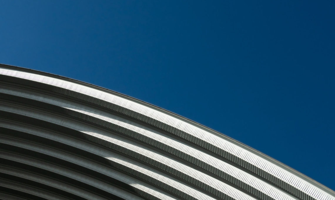 contemporary white grey metal curve architecture on blue sky background