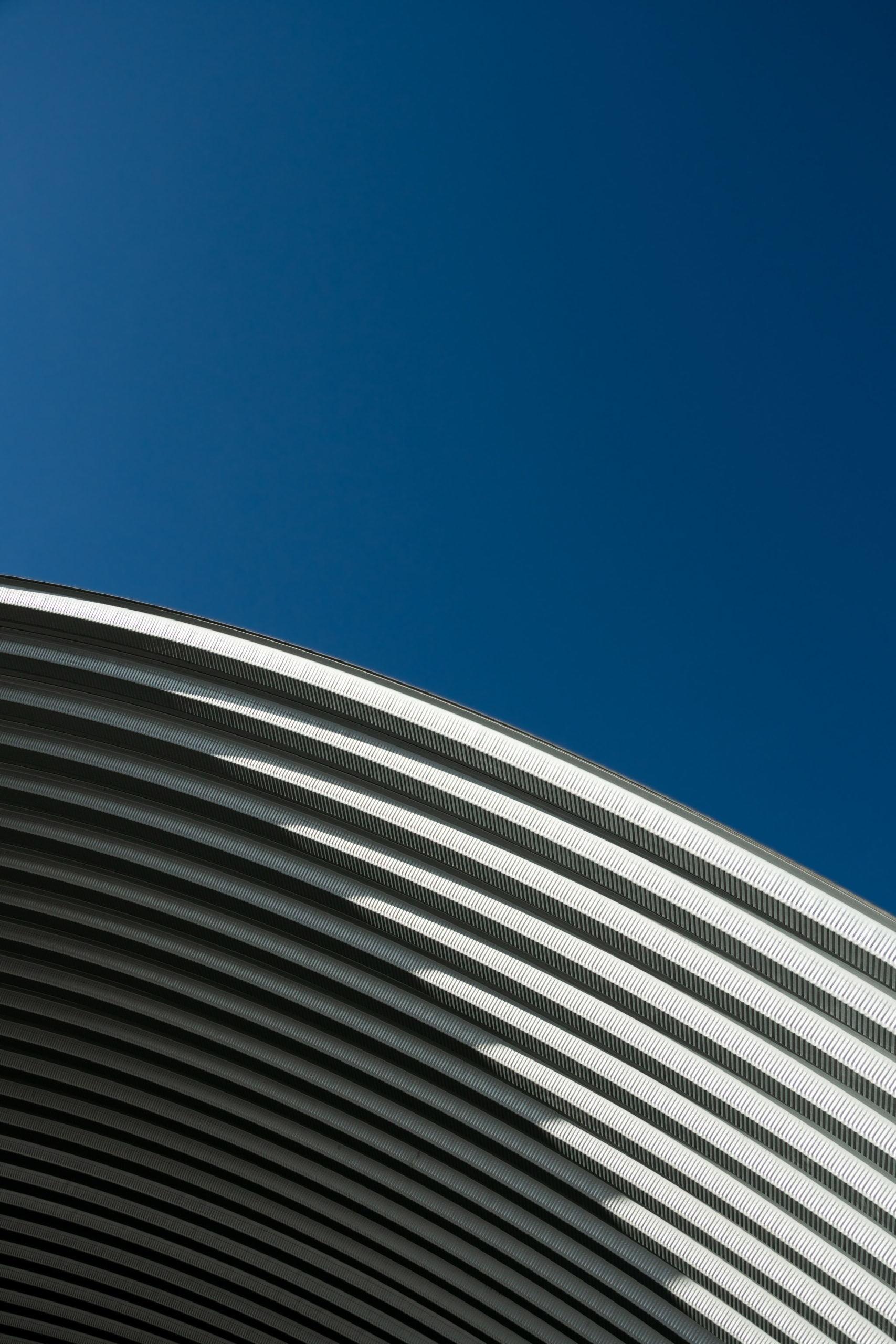 contemporary white grey metal curve architecture on blue sky background