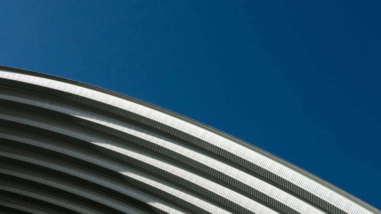 contemporary white grey metal curve architecture on blue sky background