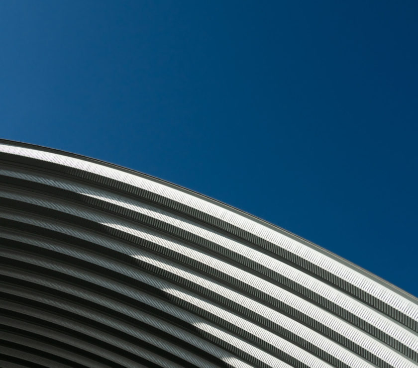 contemporary white grey metal curve architecture on blue sky background